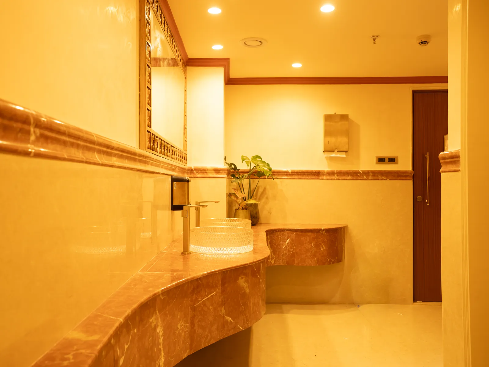 Washroom with marble counter and timber door — Chalukya Samrat